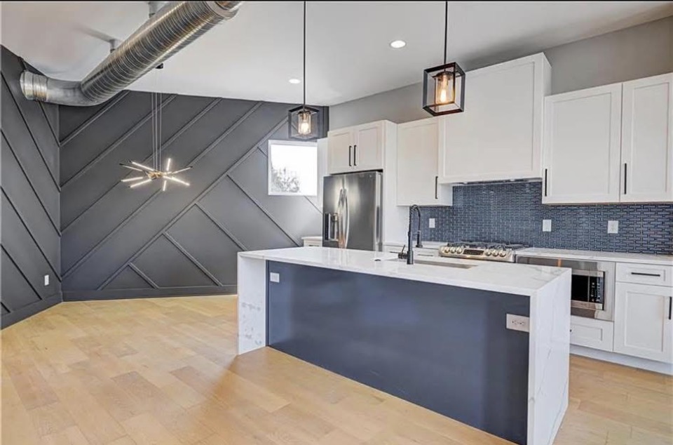 Whole-home kitchen renovation in Indianapolis with white cabinets, quartz island, and custom navy accent wall