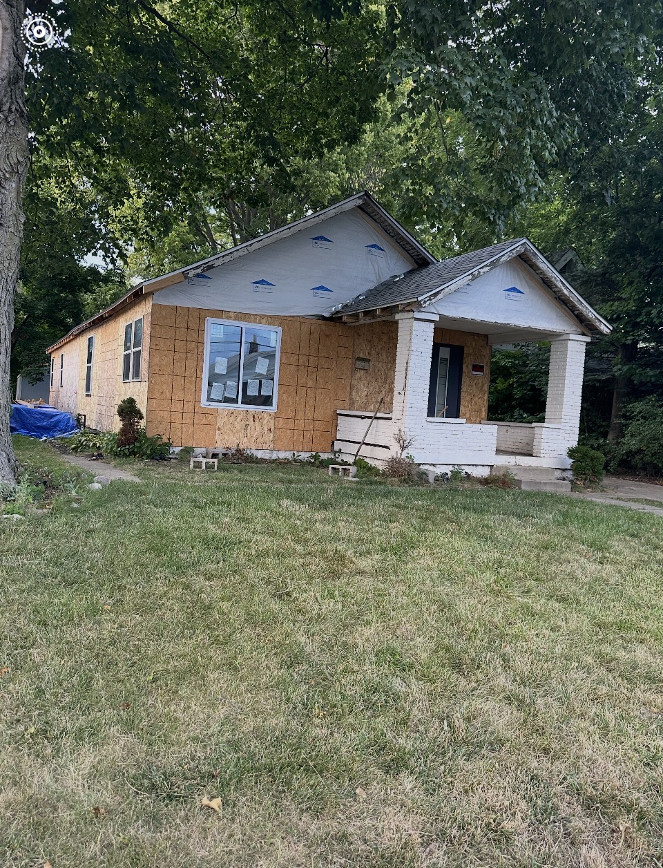 Indianapolis bungalow mid-renovation with exposed OSB sheathing and house wrap before new siding