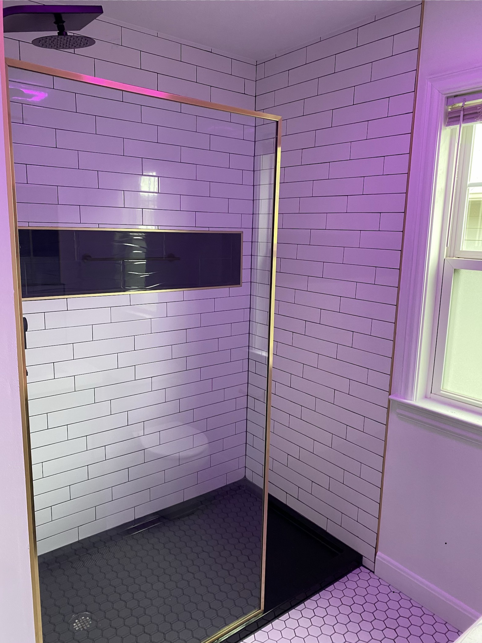 New white subway tile shower with recessed niche and frameless sliding glass door in Indianapolis